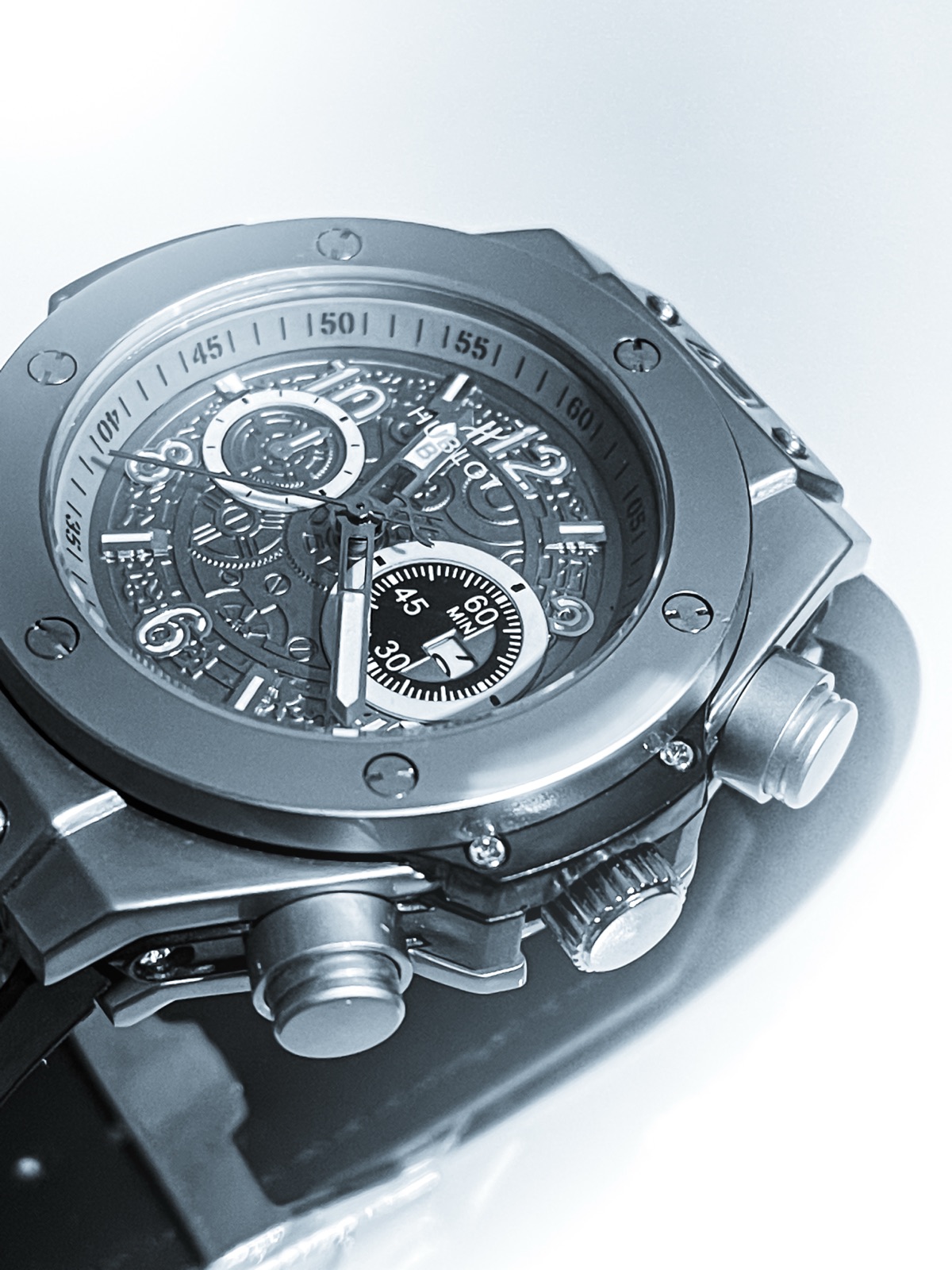 Macro study of a Swiss chronograph, brushed steel on white — Mécanique
